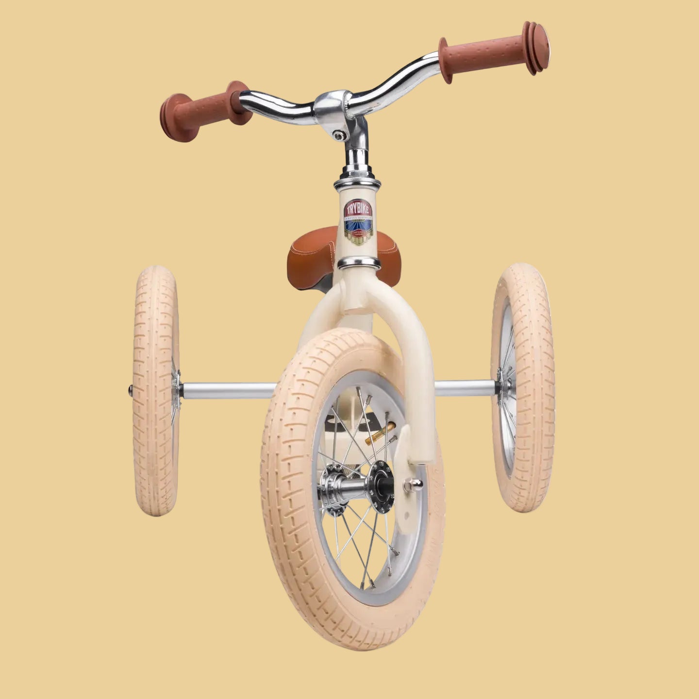 Children's tricycle with beige tires and brown handlebars on a white background
